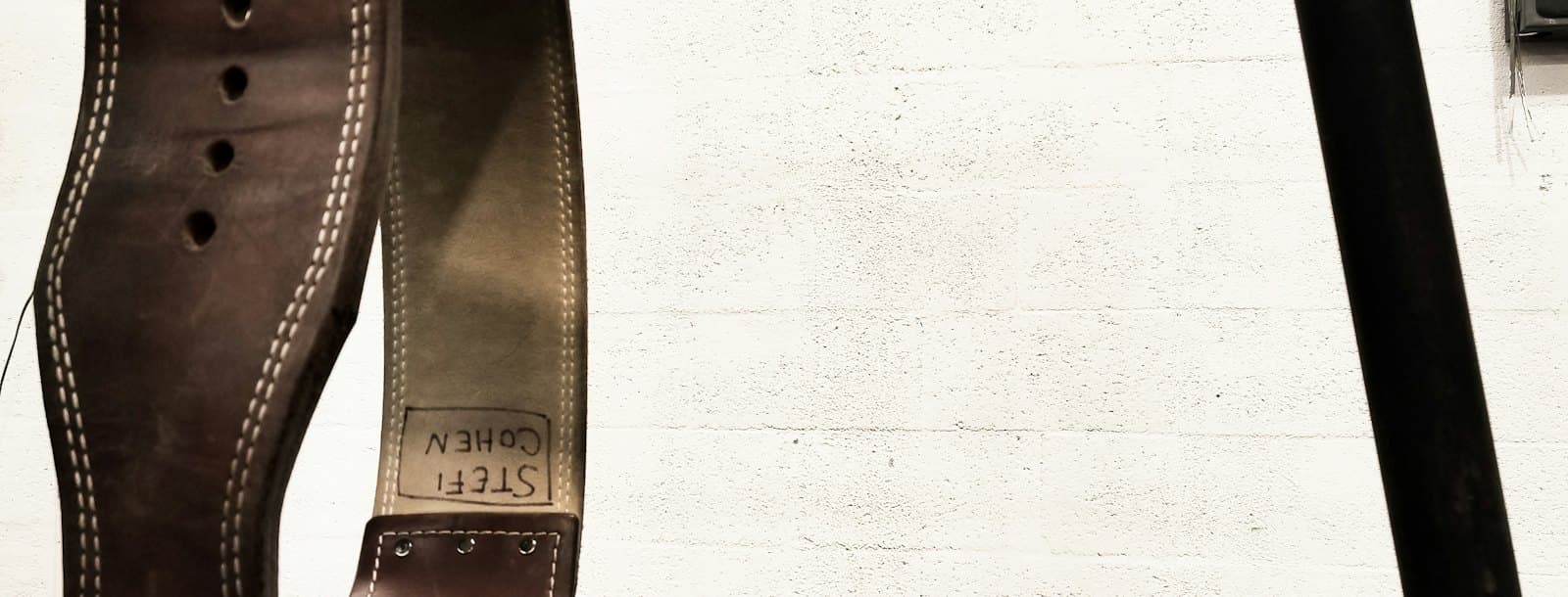 Close view of a thick leather belt and its stitching